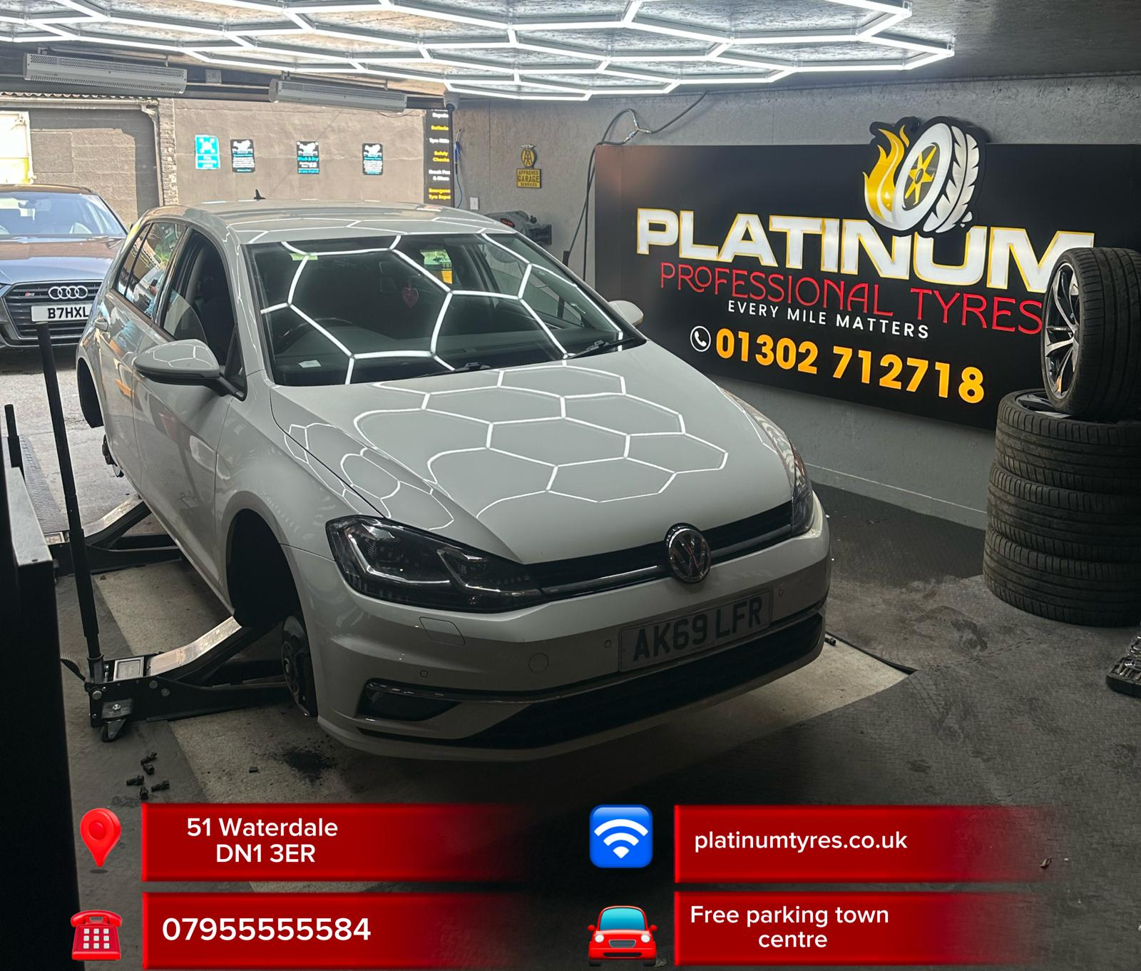 White VW Golf inside the Platinum Professional Tyres workshop under hexagonal LED lights
